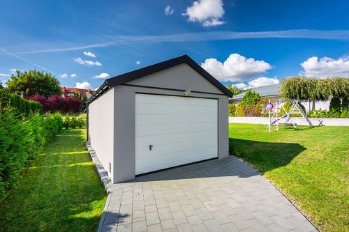 A detached garage in a green garden at summer